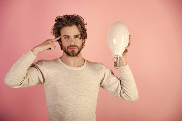 thoughtful guy has an idea on pink background, morning. - Foto, Imagen
