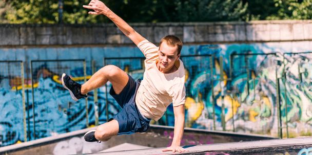 Adult man training parkour while jump over obstacles - Zdjęcie, obraz