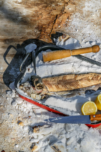 塩の地殻の下の魚を調理します。夏のランチ。素朴なスタイルの健康食品. - 写真・画像