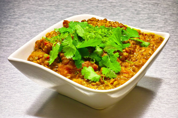 Moong Dahl, sopa de lentejas vegetariana india, en tazón blanco. Fondo de aluminio
. - Foto, imagen