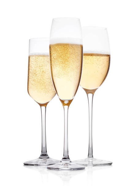 Elegantes copas de champán amarillo con burbujas sobre fondo blanco con reflejo
 - Foto, Imagen