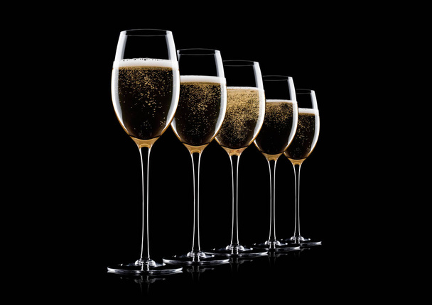 Elegant glasses of yellow champagne with bubbles on black background with reflection - Photo, Image