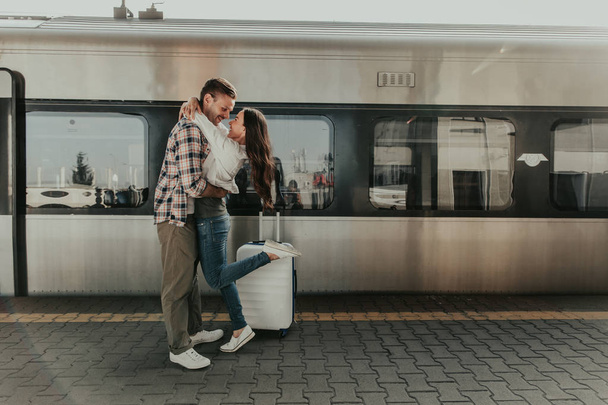 Cheerful girl embracing cheerful male on platform - Valokuva, kuva