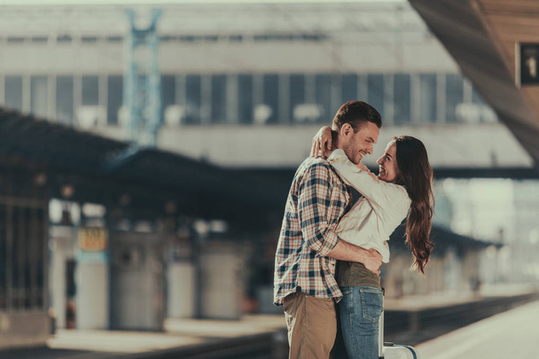 Positive man hugging cheerful female on platform - Фото, зображення