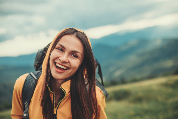 Delighted young woman standing in the mountains - Photo, image