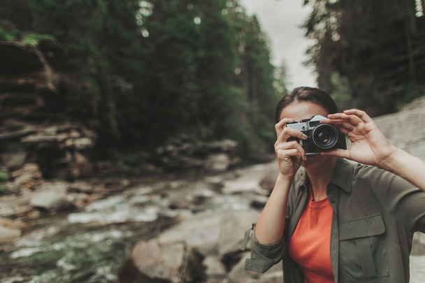 Nice enthusiastic woman making photos in the forest - 写真・画像