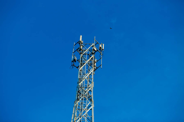Mobiele ontvanger en zender antenne toren, antenne tower gebouw met de blauwe lucht. Close-up van de antenne gebouw met de sky background.Communication antenne tower met de hemelachtergrond in close-up scène / zachte focus. - Foto, afbeelding