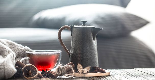 Csendélet hangulatos nappali lakberendezés elemek és egy csésze tea és egy teáskannát, egy fából készült asztal - Fotó, kép