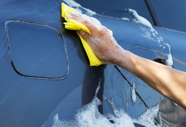 Gray car washing with yellow sponge - 写真・画像