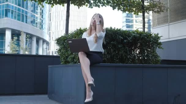 Young businesswoman working on laptop in city park business center - Video