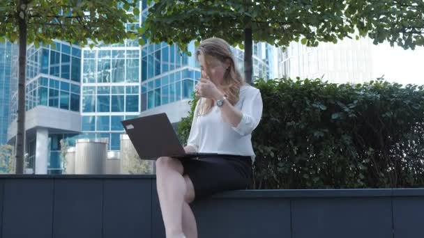 Young businesswoman working on laptop in city park business center - Video, Çekim