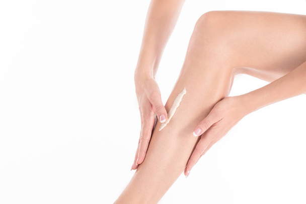 Female hands applying cream on the skin of her leg, close up - Foto, Imagem