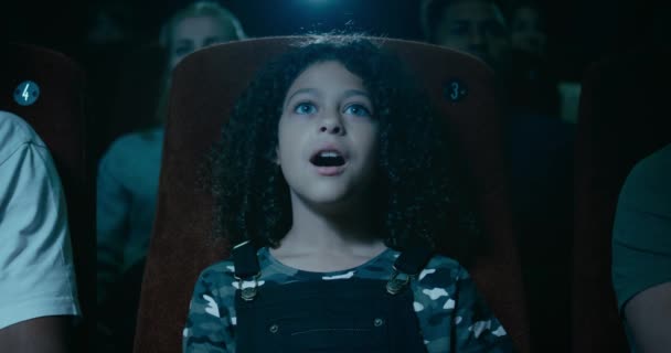 Kiinnostunut pieni tyttö elokuvateatterissa on awestruck uskomaton hetki ruudulla
 - Materiaali, video