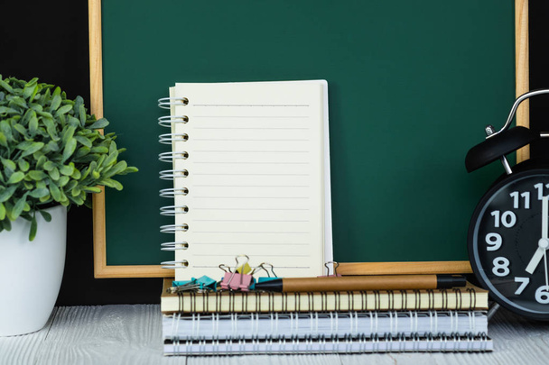 Back to school and education concept idea, green chalkboard with pile of notebook paper, stationery or school supplies. - Φωτογραφία, εικόνα