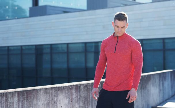 Young and sporty man training outdoor in sportswear. Handsome and fit guy in the street. Sport, health, fitness and urban athletics. - Φωτογραφία, εικόνα