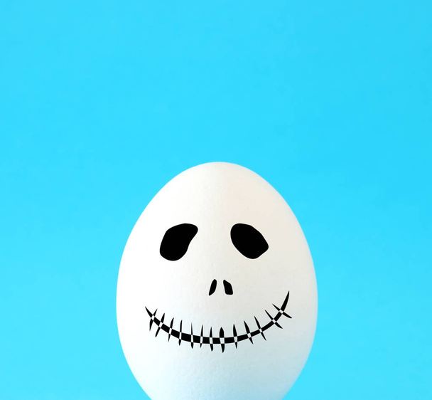 minimal and funny Halloween holiday concept. white egg with scary cute face - Фото, зображення