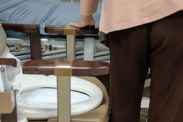 old woman use portable mobile plastic toilet near  patient bed at hospital - Foto, imagen