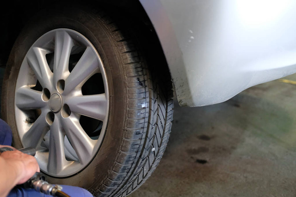 Механическая смена колеса в авторемонтной мастерской. военнослужащий заменил шины в автомобильном гараже
 - Фото, изображение
