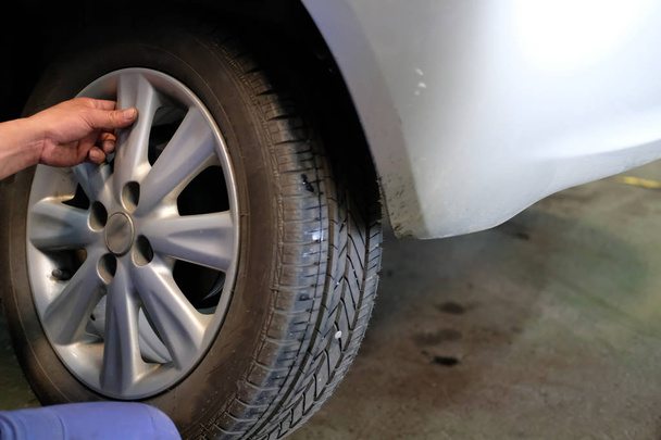 Mecânico mudança roda de carro na oficina de reparação de automóveis. serviceman substituir pneu do veículo na garagem do automóvel
 - Foto, Imagem