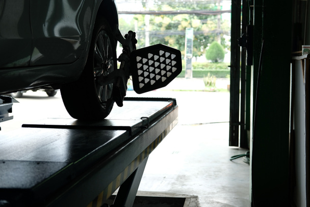 ελαστικό αυτοκινήτου που στερεώνεται με ευθυγραμμών ανακλαστήρα εργαλείο ρύθμισης για τροχό στοίχισης check in auto επισκευή γκαράζ - Φωτογραφία, εικόνα