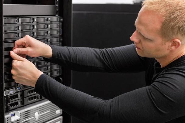 Consultor técnico masculino que ajusta los discos duros en SAN en Datace
 - Foto, Imagen