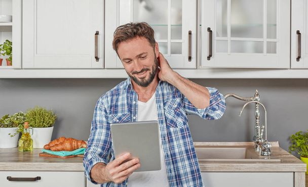 Man in kitchen with digital tablet - Фото, зображення