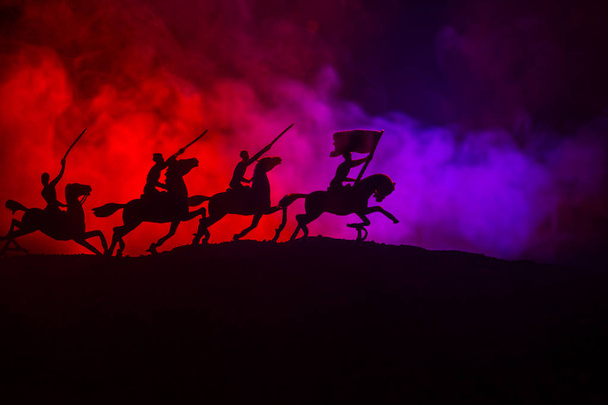 Світова війна (або воїн) вершник на коні з мечем, готовим битися, а солдати на темному туманному тонованому тлі. Бойова сцена поля битви солдатів. Вибірковий фокус
 - Фото, зображення