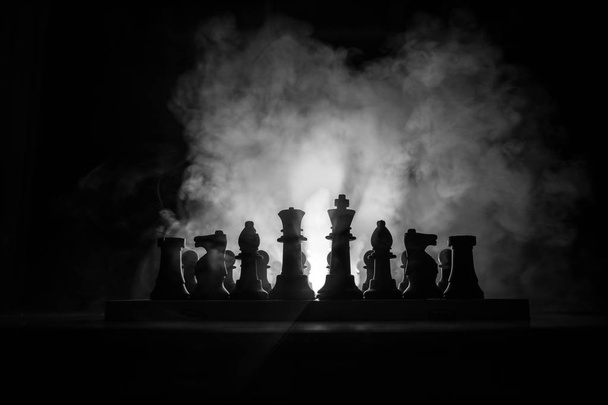 Un uomo che gioca a scacchi. Spaventosa silhouette sfocata di una persona alla scacchiera con figure scacchistiche. Sfondo scuro e nebbioso. Concentrazione selettiva. Concetto di orrore
 - Foto, immagini