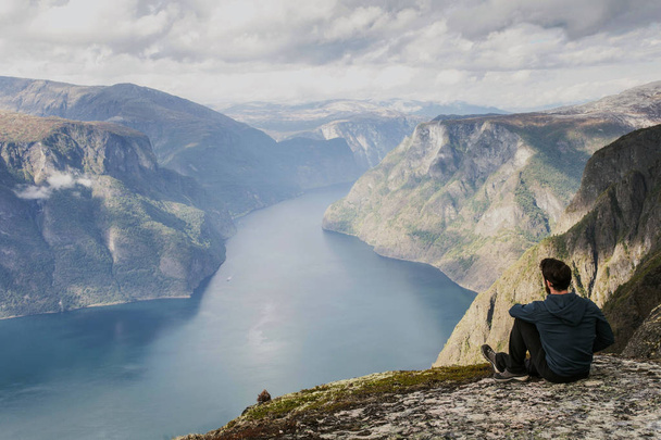 männliche Wanderer entspannen sich auf einem Berg und genießen die Aussicht - Foto, Bild