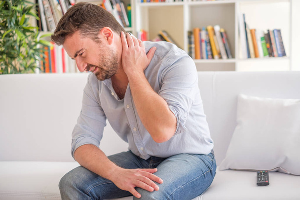 Uomo sensazione di dolore al collo a casa dopo cattiva postura
 - Foto, immagini