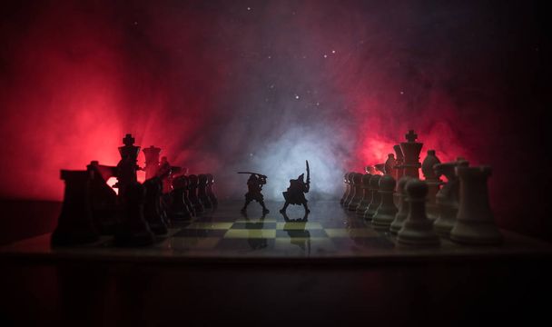 騎兵と歩兵のチェス盤で中世の戦いのシーン。ビジネスのアイデアの競争と戦略のアイデア チェス ボード ゲーム コンセプト チェス計数煙と霧と暗い背景. - 写真・画像