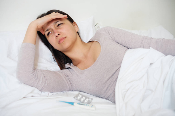 Sick woman in bed feeling headache - Photo, Image