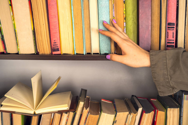 Fiatal lány könnyű ruhában könyvet olvas. A női kezek könyvet tartanak a kezükben. - Fotó, kép