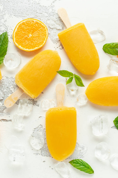 Eis am Stiel mit süßem Orangensaft auf weißem Hintergrund mit Eis - Foto, Bild