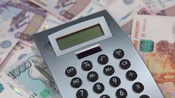 Close-up, the calculator lies on a pile of rubles. Rotation. - Video, Çekim