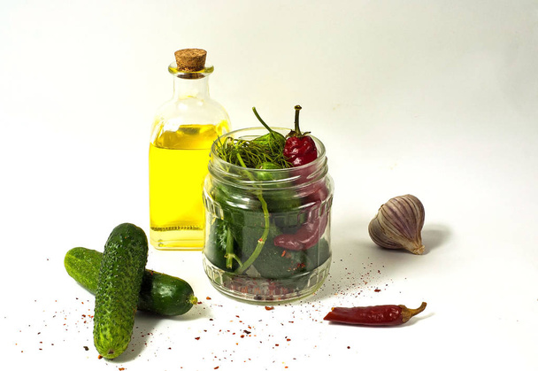 Korniszony w szklanym słoiku, ogórki kiszone z przyprawami i oliwa z oliwek. Miejsce, zbliżenie - Zdjęcie, obraz