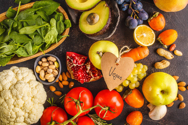 Vegan ingredientes alimentares em um fundo escuro. Legumes, frutas, cereais, nozes, feijões vista superior. Conceito de dieta à base de plantas
. - Foto, Imagem