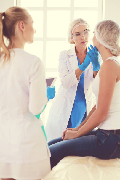 Beautiful woman face near doctor with syringe. - Zdjęcie, obraz