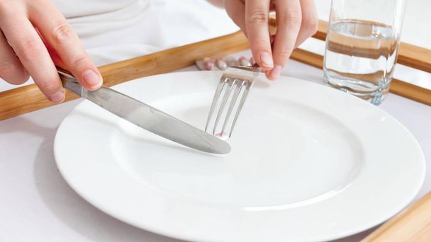 Close-up beeld van zieke vrouw pillen in plaats van diner eten - Foto, afbeelding