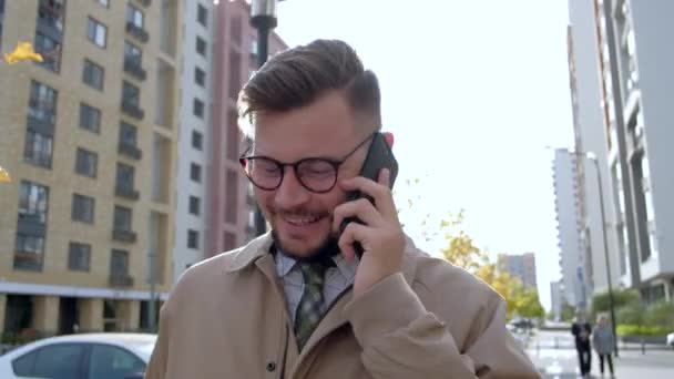 Joyful European businessman talking on the phone in outdoors - Materiał filmowy, wideo