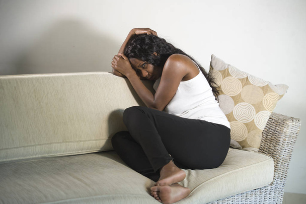 young attractive and sad black African American woman sitting depressed at home sofa couch feeling anxious and frustrated suffering depression problem and anxiety crisis crying desperate - Fotó, kép