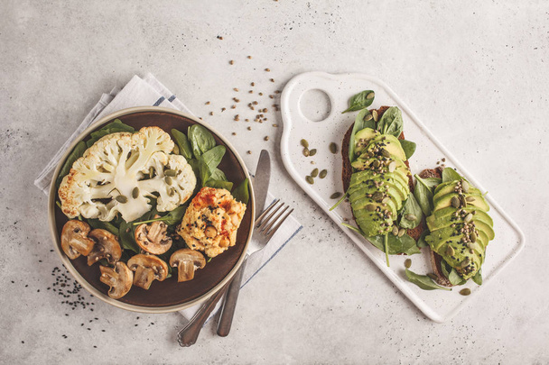 Cauliflower steak with grilled champignons and hummus and avocado toast, top view. Plant based diet concept. - Valokuva, kuva