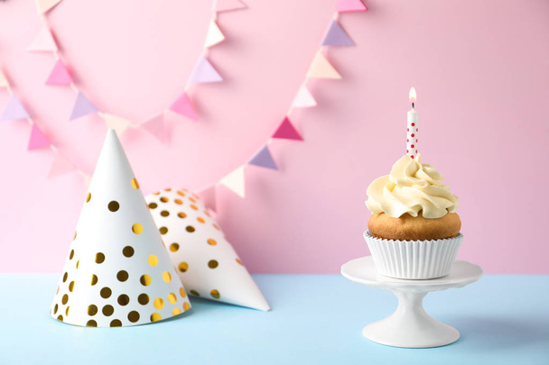 Dessert stand with delicious birthday cupcake on color background - Fotoğraf, Görsel