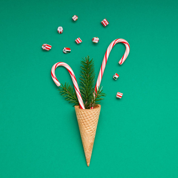 New Year Christmas Xmas holiday party celebration waffle cone candy canes fir tree branch copy space green color paper background. Square Template greeting card 2019 - 写真・画像