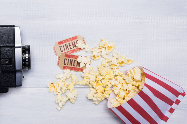 The concept of cinema with a vintage camera for filming, tickets and popcorn for watching a movie - Foto, Imagen
