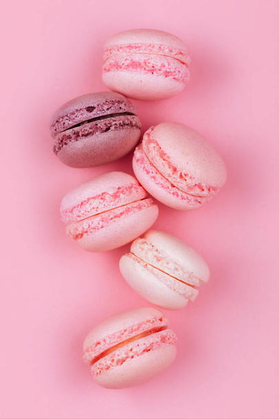 Group of sweet pink and white mini macarons on soft pink paper background with copy space for adding text - Fotó, kép