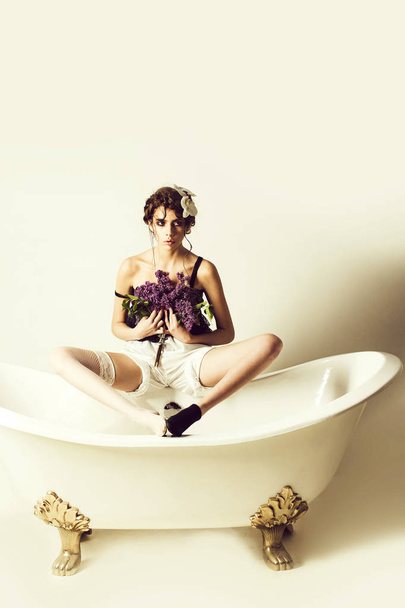 young woman resting in spa bathtub with fashionable hair, lilac - Фото, зображення