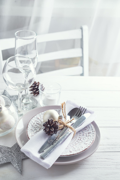 Silver and white Christmas Table Setting with christmas decorations above light window - Фото, изображение