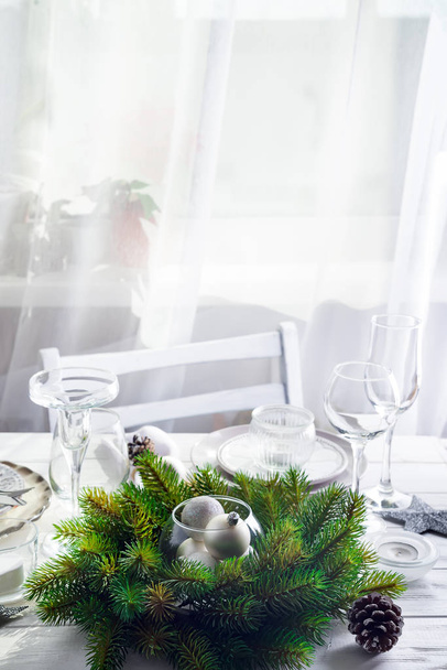 光の窓の上のクリスマスの装飾とシルバーのクリスマスのテーブルの設定とテーブルの上のおもちゃクリスマス リース - 写真・画像