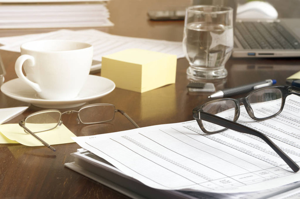 kancelářský stůl s obchodní dokumenty, brýle, notebooky a kávu, finanční koncept, vybrané zaměření, úzké hloubku ostrosti - Fotografie, Obrázek